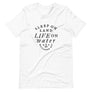 White unisex t-shirt with wording "Sleep on Land, Live on Water" written in black artistic lettering on front. Underneath this is very small semi circle stating "Mutineer Bay" centered with small anchor.