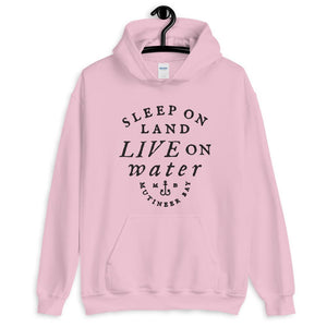Pink unisex hoodie with wording "Sleep on Land, Live on Water" written in black artistic lettering on front. Underneath this is very small semi circle stating "Mutineer Bay" centered with small anchor.