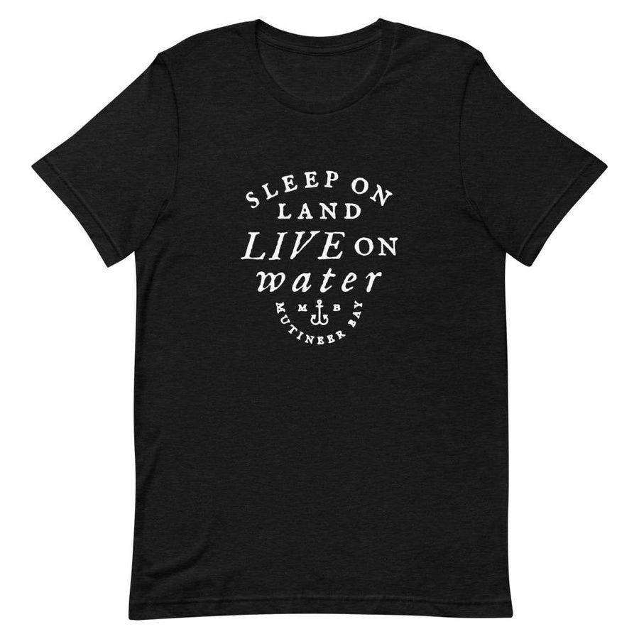Black unisex t-shirt with wording in white, "Sleep on Land, Live on Water" written in black artistic lettering on front. Underneath this is very small semi circle stating "Mutineer Bay" centered with small anchor. All lettering and images are in white.